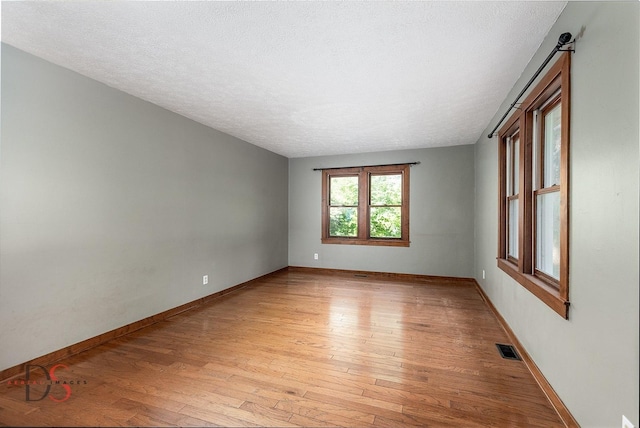 305 W 3rd St, Streator, IL 61364 - empty room featuring light wood-style floors and a textured ceiling