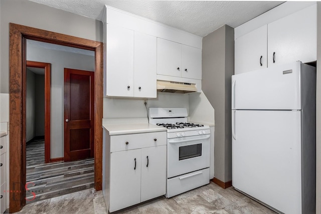 305 W 3rd St, Streator, IL 61364 - kitchen with white appliances, under cabinet range hood, light countertops, a textured ceiling, and white cabinetry