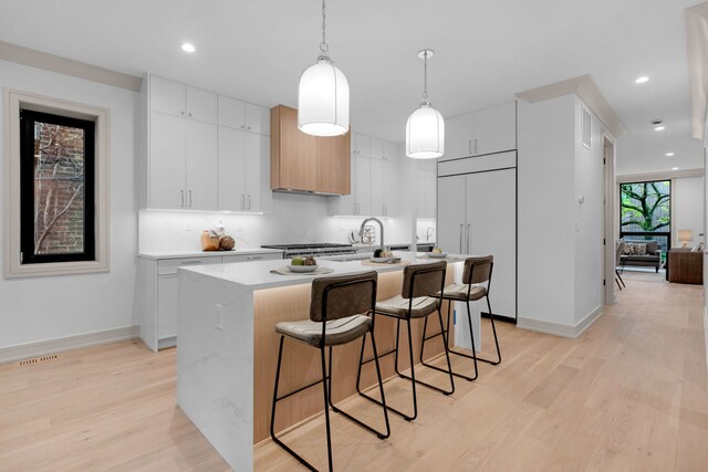 1646 N Orchard St Unit 1S, Chicago, IL 60614 - kitchen with paneled built in refrigerator, light wood-style floors, a kitchen breakfast bar, light countertops, and recessed lighting