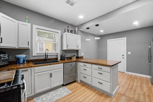 10554 S State St, Chicago, IL 60628 - kitchen featuring appliances with stainless steel finishes, butcher block countertops, a peninsula, light wood-type flooring, and recessed lighting