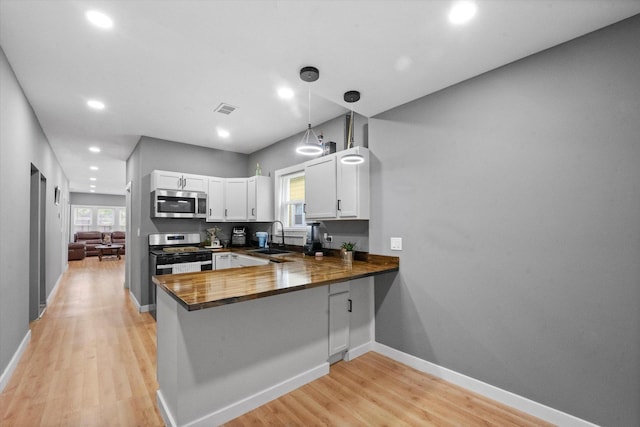 10554 S State St, Chicago, IL 60628 - kitchen featuring stainless steel appliances, white cabinetry, light wood-type flooring, healthy amount of natural light, and recessed lighting