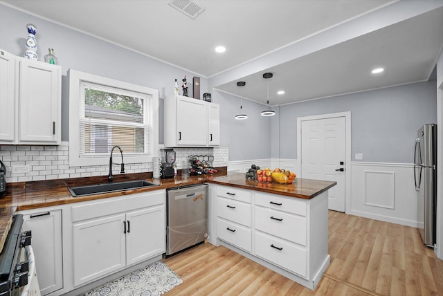 10554 S State St, Chicago, IL 60628 - kitchen with wood counters, stainless steel appliances, white cabinetry, a peninsula, and light wood-style floors