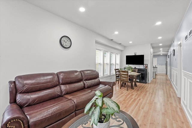 10554 S State St, Chicago, IL 60628 - living room featuring light wood-type flooring, recessed lighting, a decorative wall, and wainscoting