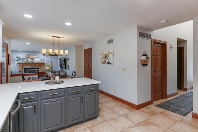 807 Eddy Rd, Bloomington, IL 61704 - kitchen with a glass covered fireplace, light countertops, dishwasher, recessed lighting, and pendant lighting