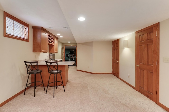 807 Eddy Rd, Bloomington, IL 61704 - kitchen featuring light carpet, recessed lighting, a peninsula, a breakfast bar area, and light countertops