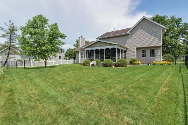 807 Eddy Rd, Bloomington, IL 61704 - back of property with a chimney, a fenced backyard, and a sunroom