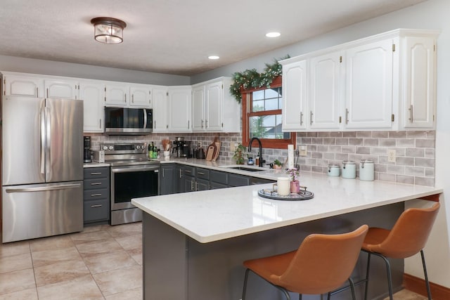 807 Eddy Rd, Bloomington, IL 61704 - kitchen with stainless steel appliances, white cabinets, backsplash, light countertops, and gray cabinetry