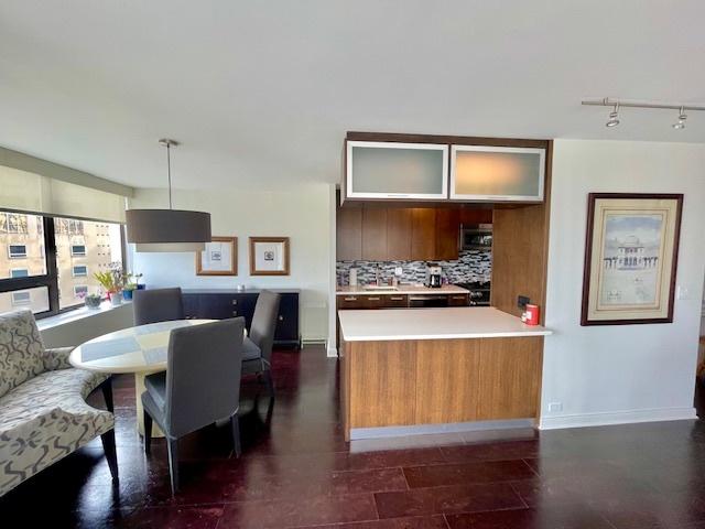 2800 N Lake Shore Dr Unit 1417, Chicago, IL 60657 - kitchen featuring decorative backsplash, glass insert cabinets, light countertops, a peninsula, and track lighting