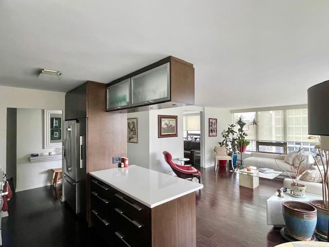 2800 N Lake Shore Dr Unit 1417, Chicago, IL 60657 - kitchen featuring stainless steel fridge, light countertops, dark wood finished floors, open floor plan, and a peninsula