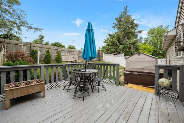 4756 Flanders Ct, Plainfield, IL 60586 - wooden deck with a hot tub, outdoor dining area, a fenced backyard, and an outbuilding
