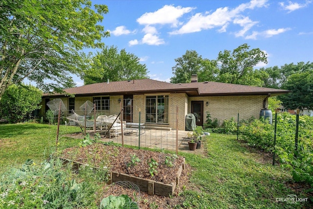 2290 Copley St, Aurora, IL 60506 - view of front of home featuring a patio area, a chimney, brick siding, and a garden