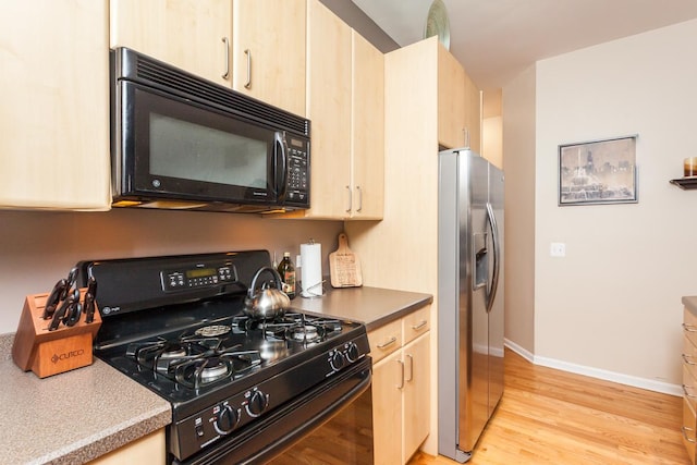 4124 N Kenmore Ave Unit Gs, Chicago, IL 60613 - kitchen featuring black appliances, light brown cabinets, and light wood-style flooring