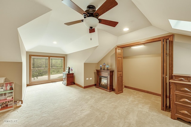 2800 Arbor Ln, Oswego, IL 60543 - additional living space featuring vaulted ceiling, light carpet, ceiling fan, a skylight, and a glass covered fireplace