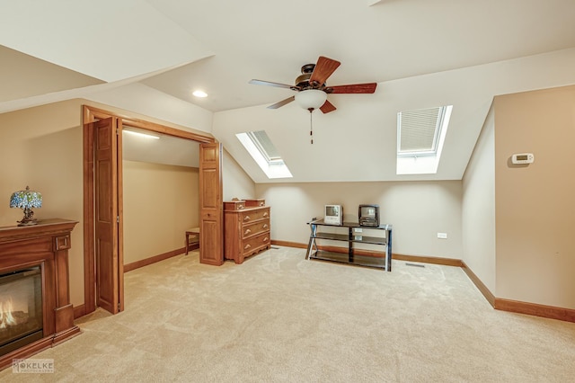 2800 Arbor Ln, Oswego, IL 60543 - bonus room featuring a skylight, ceiling fan, light carpet, vaulted ceiling, and a glass covered fireplace
