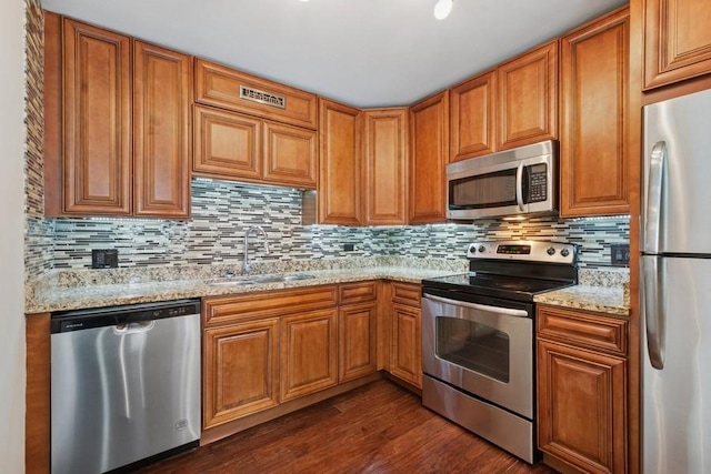 200 N Dearborn St Unit 2402, Chicago, IL 60601 - kitchen with appliances with stainless steel finishes, dark wood-type flooring, decorative backsplash, light stone countertops, and brown cabinetry