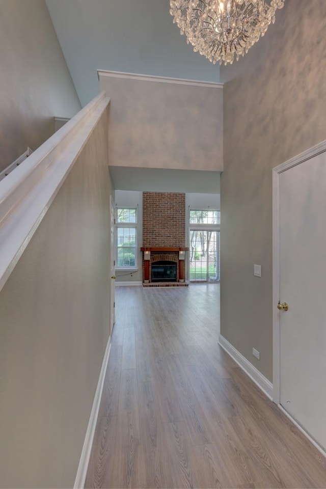 195 Island Ct Unit 195, Schaumburg, IL 60193 - unfurnished living room with a high ceiling, wood finished floors, a chandelier, and a brick fireplace