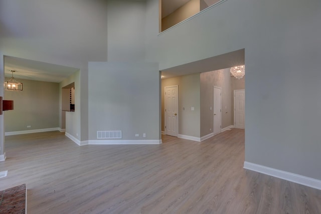 195 Island Ct Unit 195, Schaumburg, IL 60193 - unfurnished living room featuring a chandelier, a towering ceiling, and wood finished floors