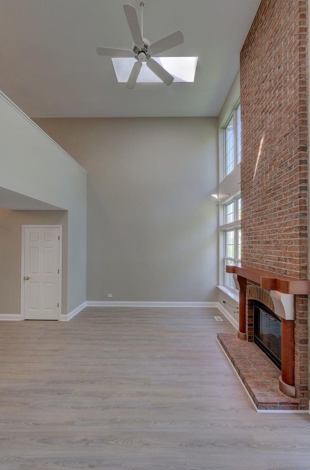 195 Island Ct Unit 195, Schaumburg, IL 60193 - unfurnished living room with high vaulted ceiling, ceiling fan, wood finished floors, a fireplace, and a skylight