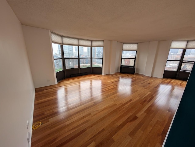 899 S Plymouth Ct Unit 1703, Chicago, IL 60605 - unfurnished living room featuring light wood-type flooring and a textured ceiling