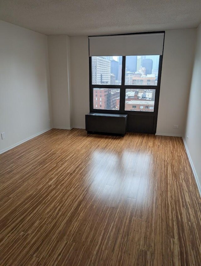 899 S Plymouth Ct Unit 1703, Chicago, IL 60605 - unfurnished room featuring wood finished floors and a textured ceiling