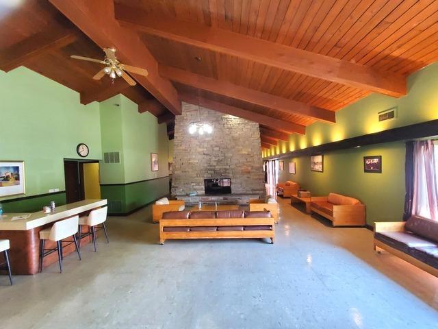 828 E Old Willow Rd Unit 109, Prospect Heights, IL 60070 - living area with a fireplace, a ceiling fan, and wood ceiling