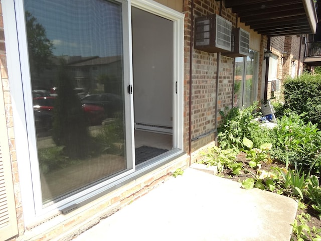 828 E Old Willow Rd Unit 109, Prospect Heights, IL 60070 - doorway to property with a baseboard radiator, brick siding, a patio area, and a wall unit AC