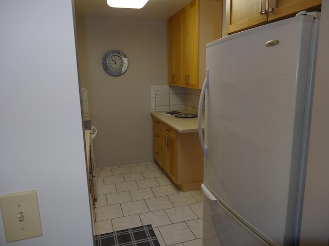 828 E Old Willow Rd Unit 109, Prospect Heights, IL 60070 - kitchen featuring freestanding refrigerator, backsplash, light countertops, and light tile patterned floors