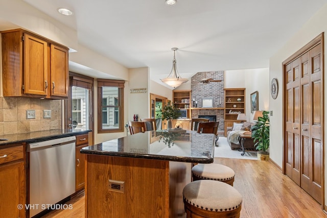 321 Breckenridge Dr, Aurora, IL 60504 - kitchen featuring dishwasher, a breakfast bar, brown cabinets, a fireplace, and light wood-style flooring