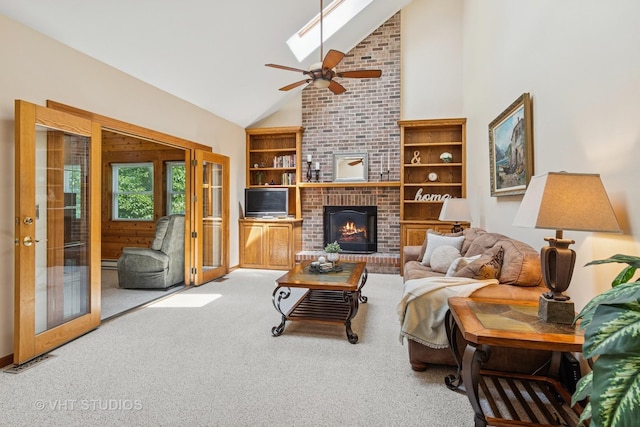 321 Breckenridge Dr, Aurora, IL 60504 - carpeted living area with french doors, high vaulted ceiling, a brick fireplace, ceiling fan, and a skylight