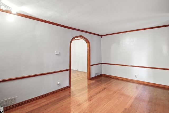 8619 S Jeffery Blvd, Chicago, IL 60617 - spare room with crown molding, arched walkways, and hardwood / wood-style flooring