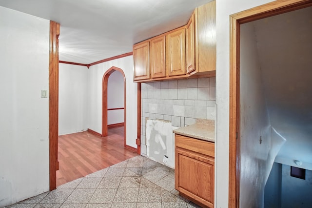 8619 S Jeffery Blvd, Chicago, IL 60617 - kitchen with arched walkways, backsplash, light countertops, and ornamental molding