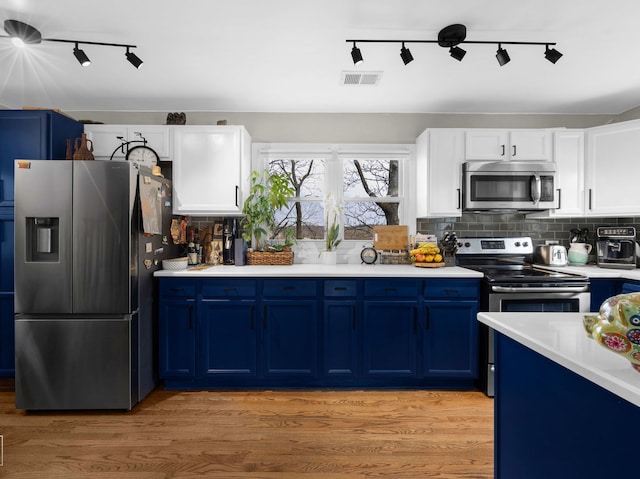 711 Illinois St, Lemont, IL 60439 - kitchen featuring stainless steel appliances, blue cabinetry, track lighting, and light countertops