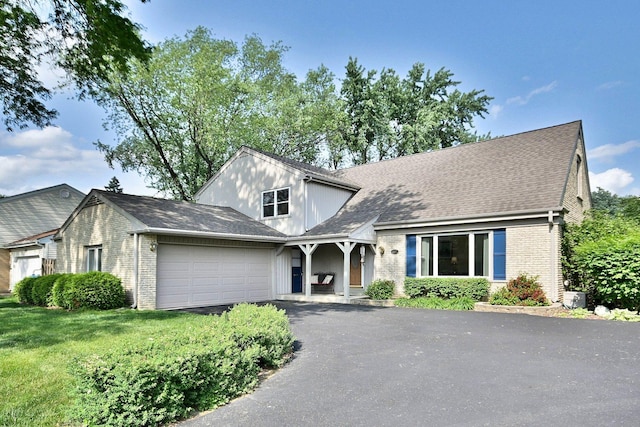 537 S Echo Ln, Palatine, IL 60067 - view of front of home featuring brick siding, an attached garage, asphalt driveway, a front yard, and roof with shingles