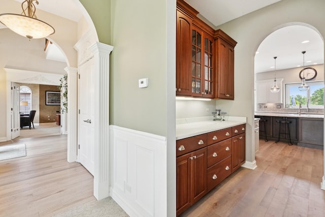 6N707 Brookhaven Ln, Saint Charles, IL 60175 - bar featuring arched walkways, light wood finished floors, decorative columns, decorative light fixtures, and recessed lighting