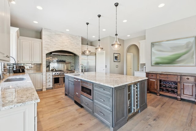 6N707 Brookhaven Ln, Saint Charles, IL 60175 - kitchen featuring gray cabinets, arched walkways, light wood finished floors, tasteful backsplash, and recessed lighting