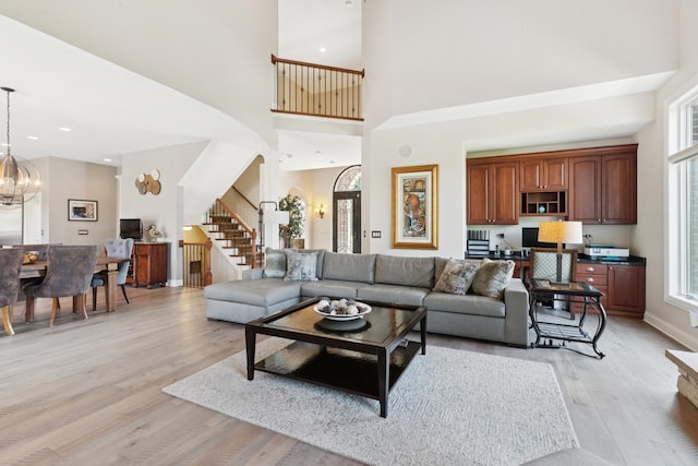 6N707 Brookhaven Ln, Saint Charles, IL 60175 - living area featuring stairway, light wood-style flooring, a towering ceiling, a chandelier, and recessed lighting