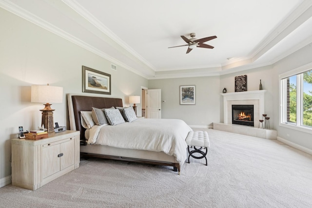 6N707 Brookhaven Ln, Saint Charles, IL 60175 - bedroom with light colored carpet, crown molding, a tiled fireplace, a tray ceiling, and ceiling fan