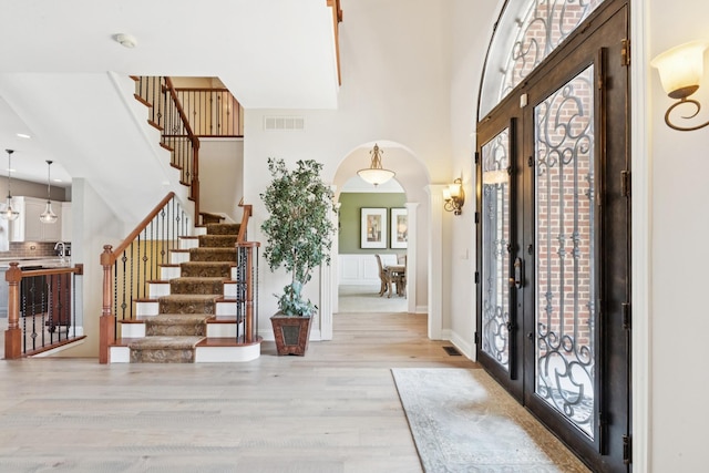 6N707 Brookhaven Ln, Saint Charles, IL 60175 - foyer entrance featuring arched walkways, light wood-style floors, stairway, a towering ceiling, and french doors