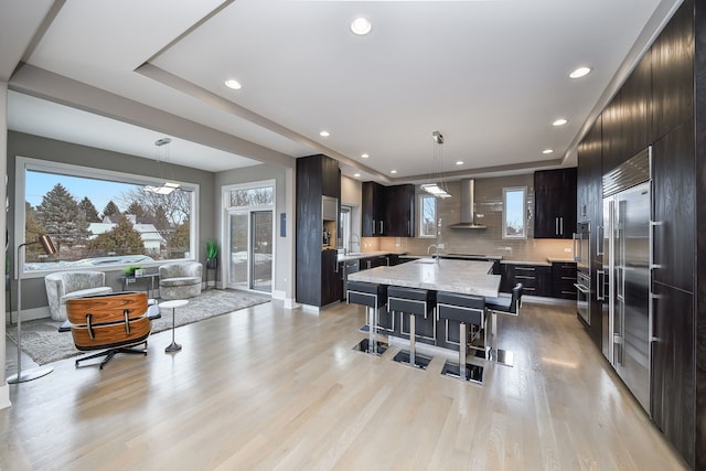 2412 Sharon Ct, Naperville, IL 60564 - kitchen featuring wall chimney range hood, modern cabinets, stainless steel built in fridge, a center island, and hanging light fixtures