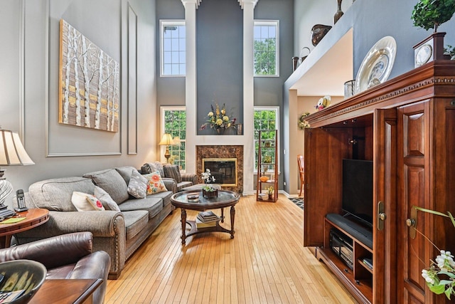 147 Fulbright Ln, Schaumburg, IL 60194 - living room with light wood-type flooring, a high ceiling, a fireplace, and ornate columns