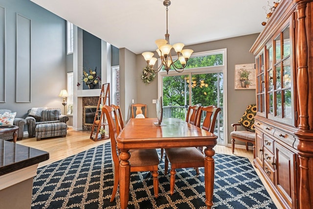 147 Fulbright Ln, Schaumburg, IL 60194 - dining room featuring wood finished floors, a chandelier, and a glass covered fireplace