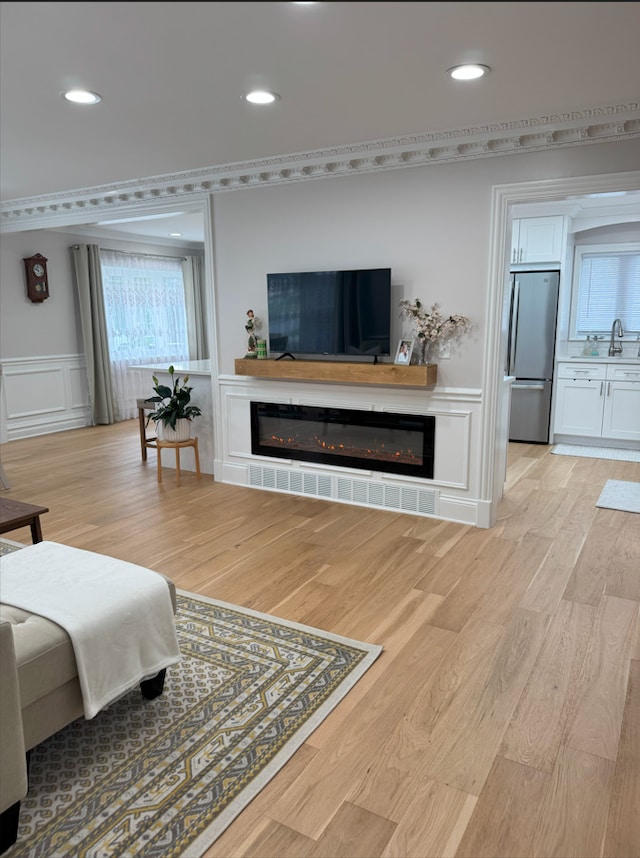 1517 Webster Ln, Des Plaines, IL 60018 - living room with a decorative wall, a glass covered fireplace, light wood-style flooring, recessed lighting, and a wainscoted wall