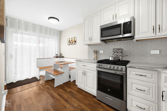 7312 Winthrop Way Unit 11, Downers Grove, IL 60516 - kitchen featuring appliances with stainless steel finishes, tasteful backsplash, white cabinetry, and dark wood-style floors