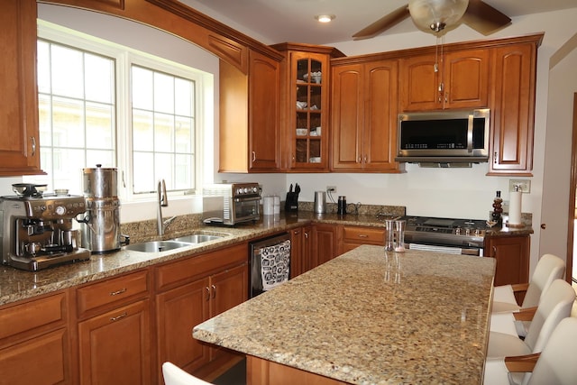 5125 N La Crosse Ave, Chicago, IL 60630 - kitchen featuring stainless steel appliances, a kitchen breakfast bar, light stone counters, glass insert cabinets, and ceiling fan