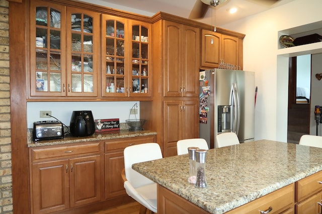 5125 N La Crosse Ave, Chicago, IL 60630 - kitchen with stainless steel fridge with ice dispenser, light stone countertops, glass insert cabinets, and brown cabinets