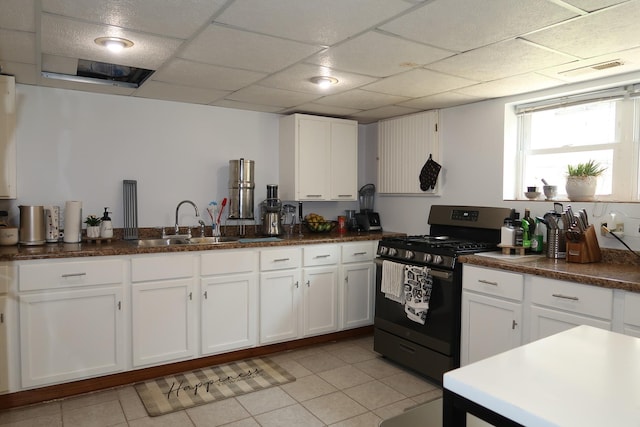 5125 N La Crosse Ave, Chicago, IL 60630 - kitchen with stainless steel range with gas stovetop, white cabinets, a paneled ceiling, dark countertops, and light tile patterned floors