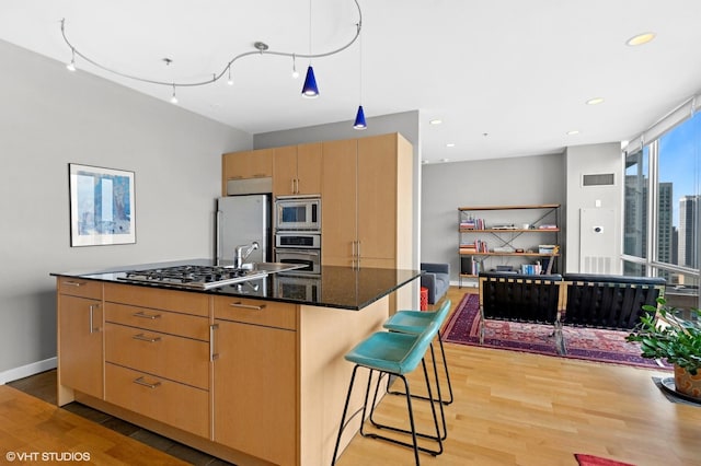 653 N Kingsbury St Unit 2202, Chicago, IL 60654 - kitchen with stainless steel appliances, light wood finished floors, a center island, a kitchen bar, and recessed lighting