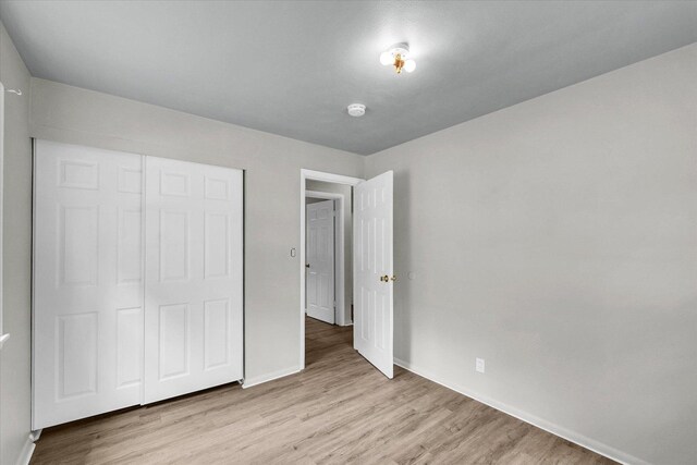 1413 Garden Hills Dr, Champaign, IL 61821 - unfurnished bedroom with light wood-type flooring and a closet