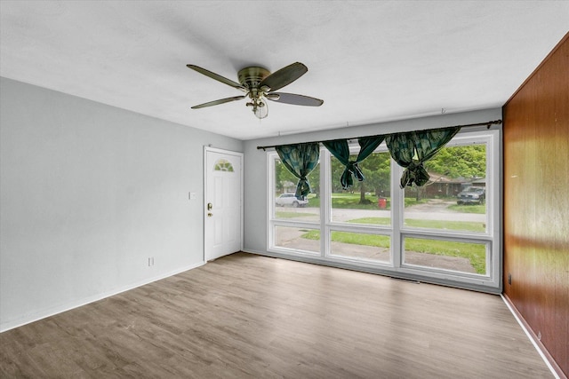 1413 Garden Hills Dr, Champaign, IL 61821 - spare room featuring healthy amount of natural light, wood finished floors, ceiling fan, and wooden walls