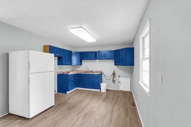 1413 Garden Hills Dr, Champaign, IL 61821 - kitchen featuring freestanding refrigerator, blue cabinetry, light wood finished floors, and healthy amount of natural light